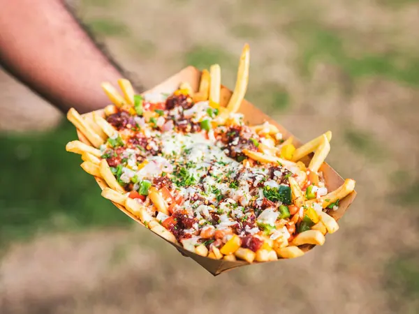 Pommes frites med ost og topping